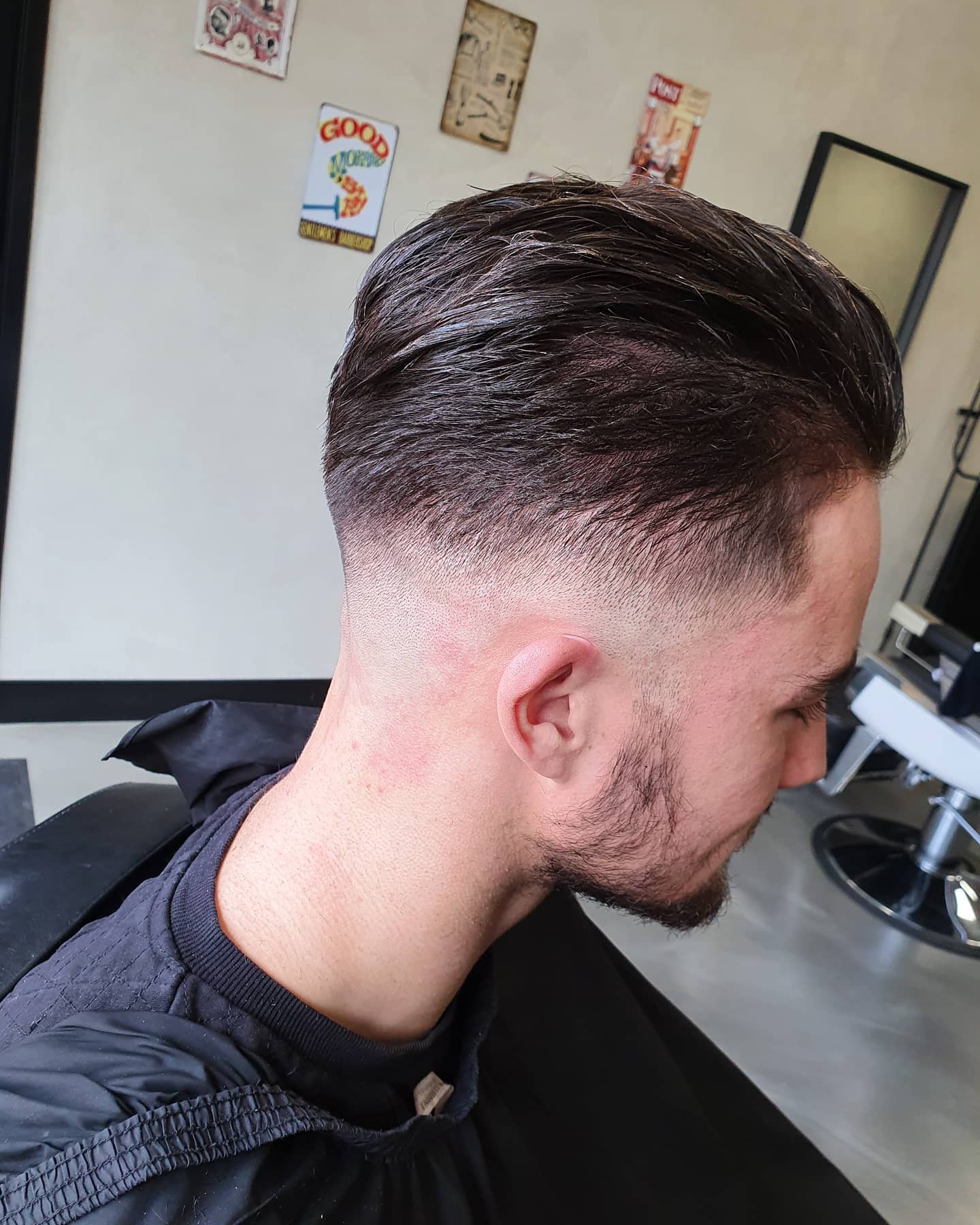 Koperkleurige zijscheiding met low skin fade en korte baard